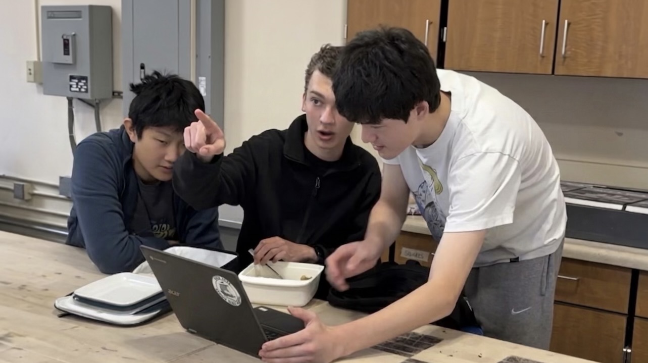 Three Art + Tech members collaborate around a laptop during the club’s first year.