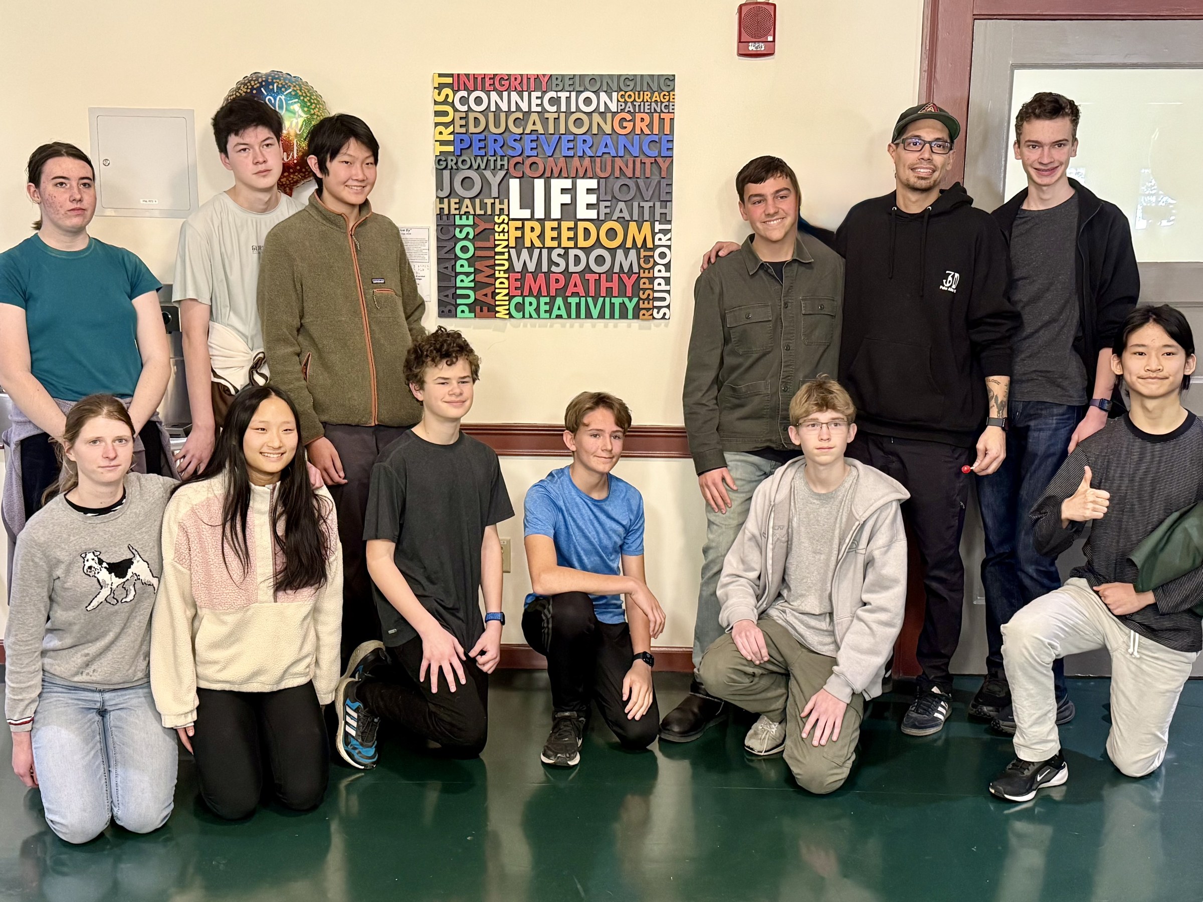 Art + Tech members stand together beside the completed Words We Live By installation.