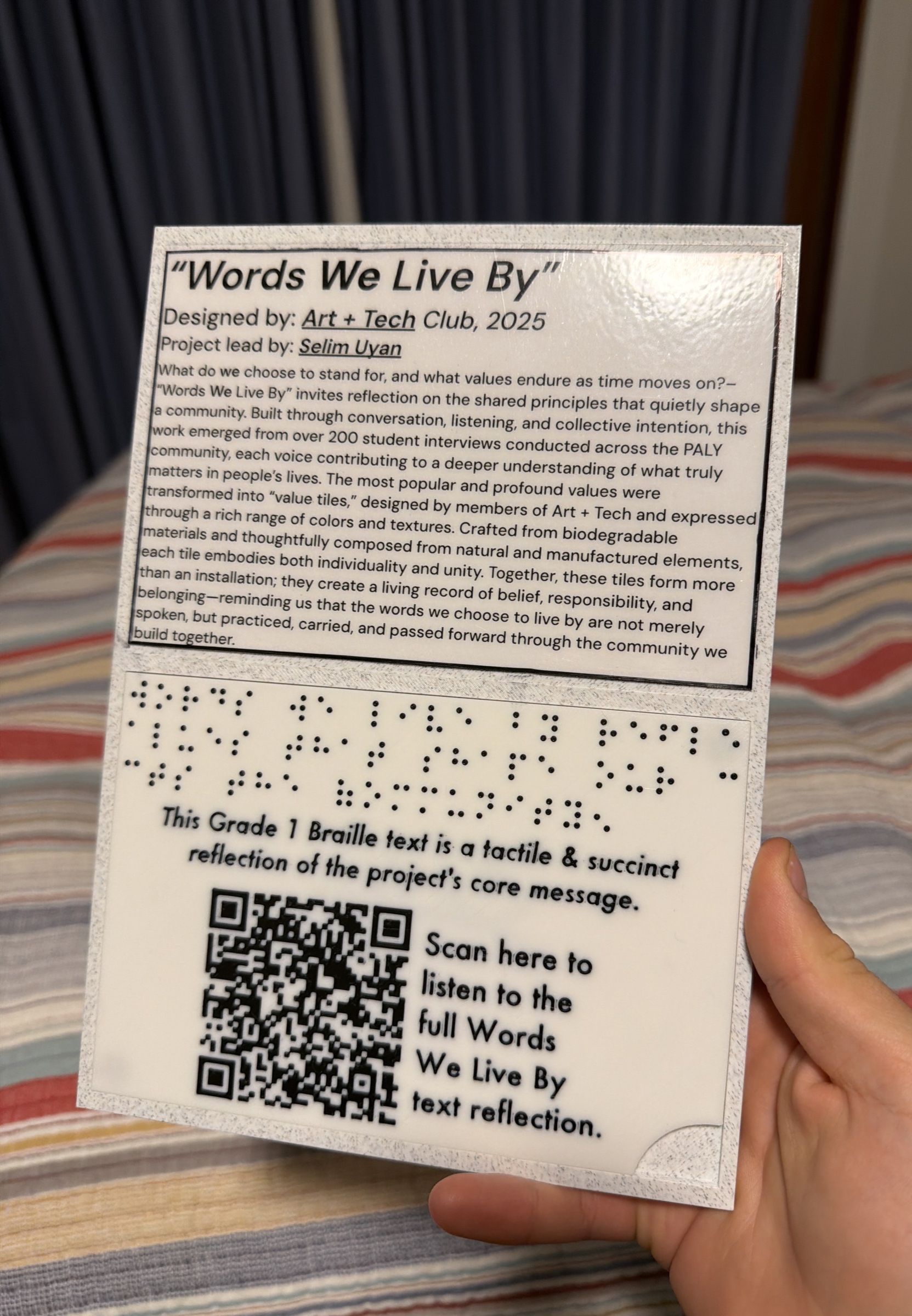 The finished Words We Live By wall label with project text, Braille, and an audio-access QR code.